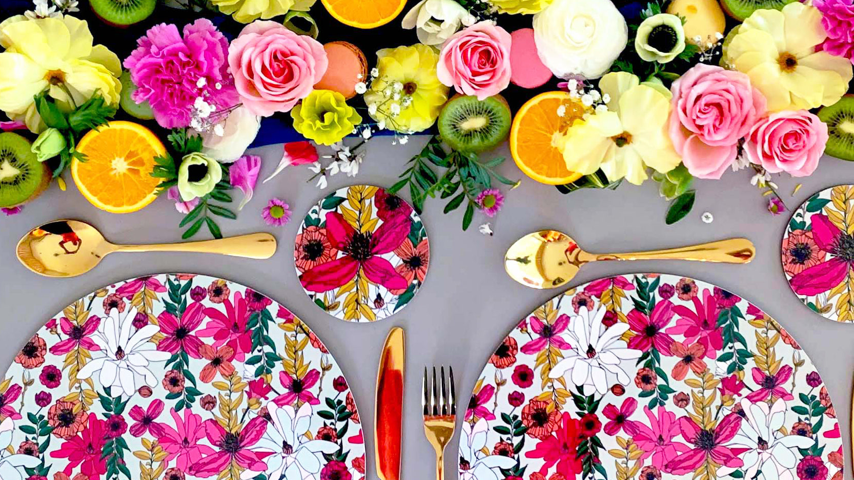 Beautiful colourful tablescape featuring melamine placemats by Bean and Bemble, summer fruits and pretty flowers