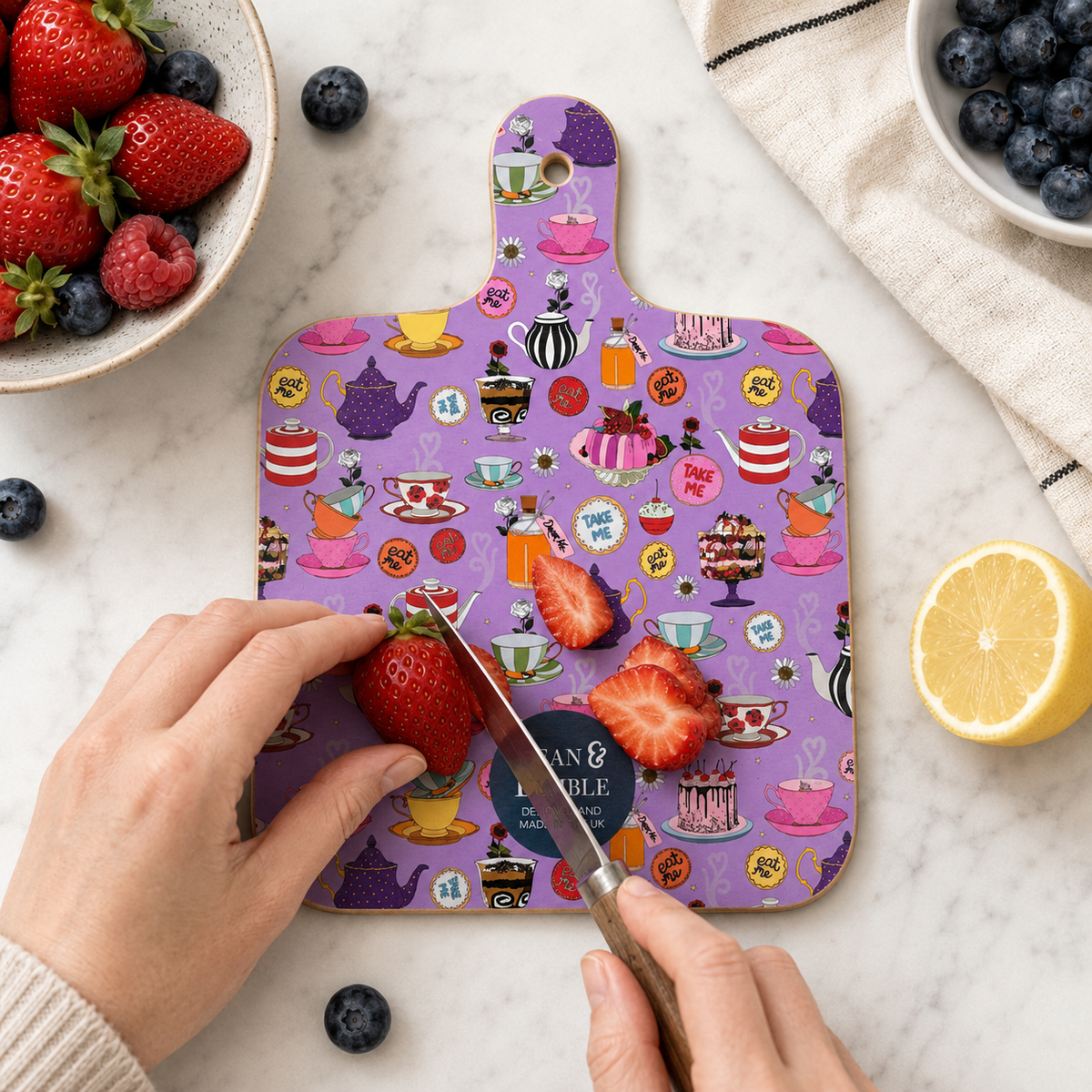 Colourful Alice in Wonderland mini chopping board styled with strawberries and flowers, featuring Alice and the Queen of Hearts.