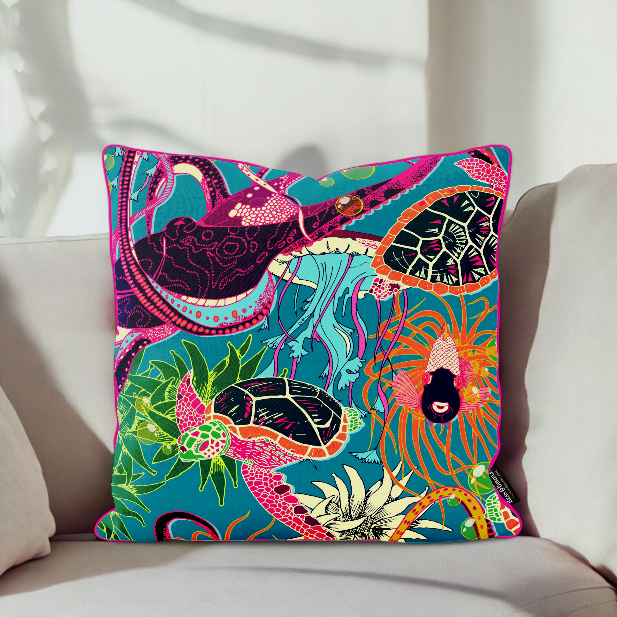 Brightly patterned octopus and turtle outdoor garden cushion on a cream conservatory couch in the sun