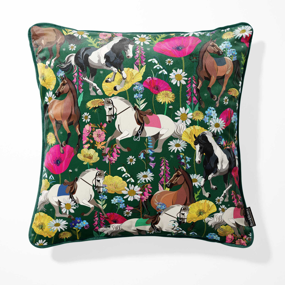 A square throw pillow featuring a vibrant, all-over print of horses and wildflowers on a dark green background, shown against a plain white studio backdrop.
