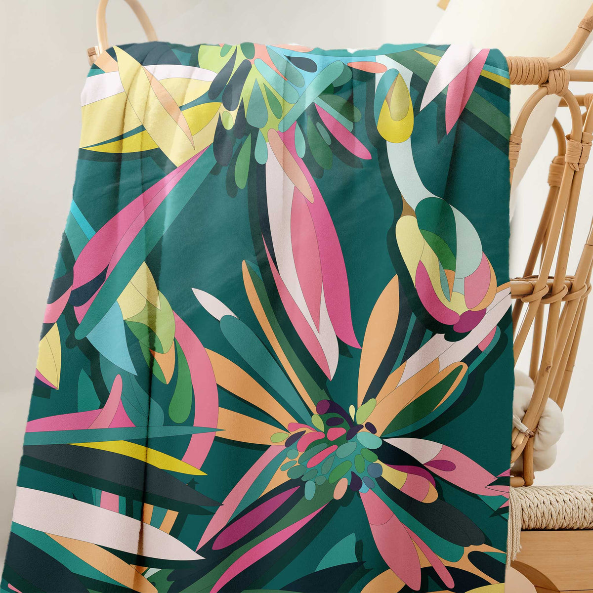 Teal floral sherpa blanket with multicolor leaf pattern, draped on chair