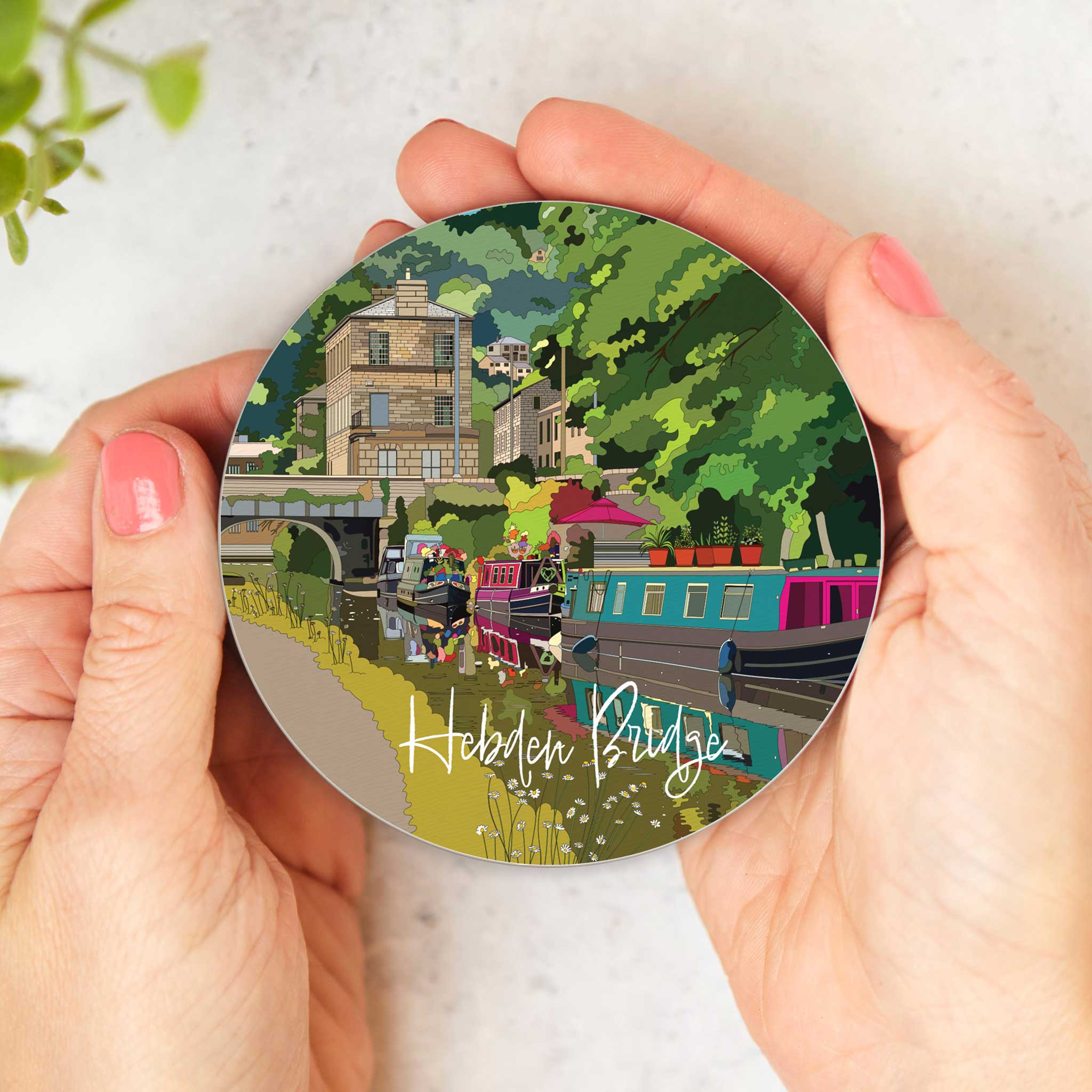 Melamine coaster held in hands, featuring Hebden Bridge canal scene and cork back