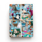 Cats on Sofas wrapping paper on a wrapped gift, featuring Bengal, Persian, Siamese, tabby and fluffy cats on a bright blue background.