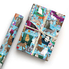 Colourful cat wrapping paper with wrapped present and roll, featuring illustrated cats lounging on sofas and armchairs with paw prints and cat toys.