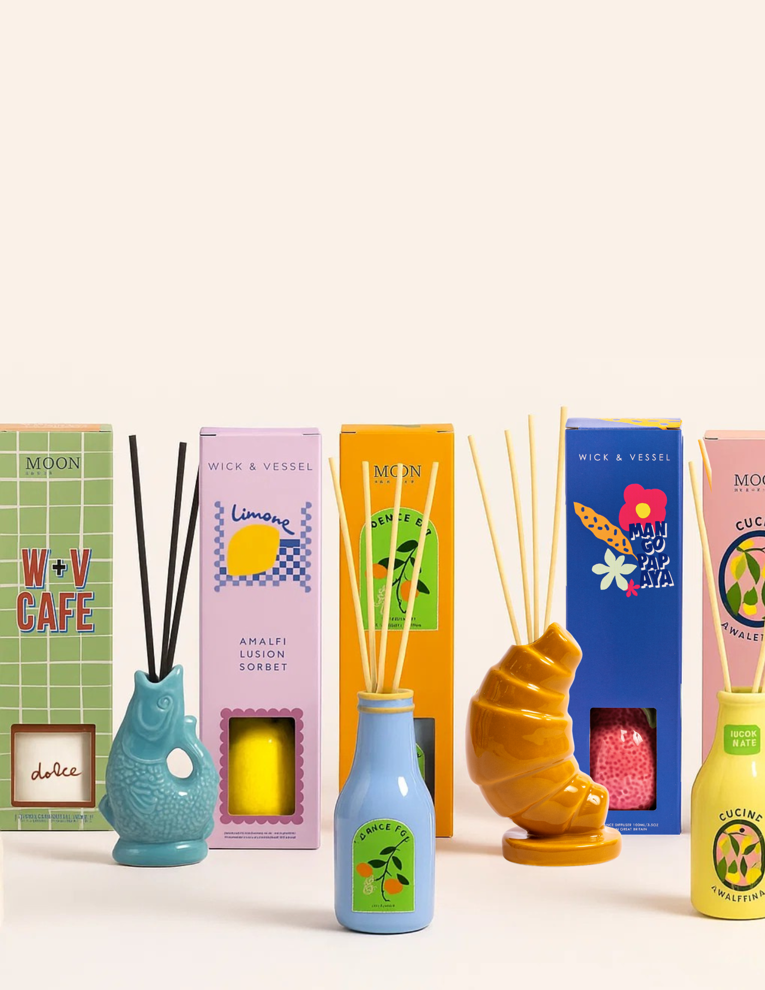 Assorted reed diffuser bottles with colorful boxes, including blue and yellow designs