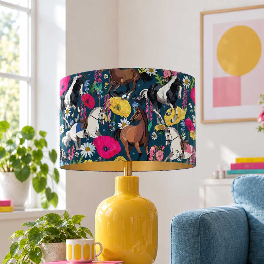Equestrian Meadow navy horse velvet lampshade on a yellow table lamp in a bright colourful living room with a blue sofa.
