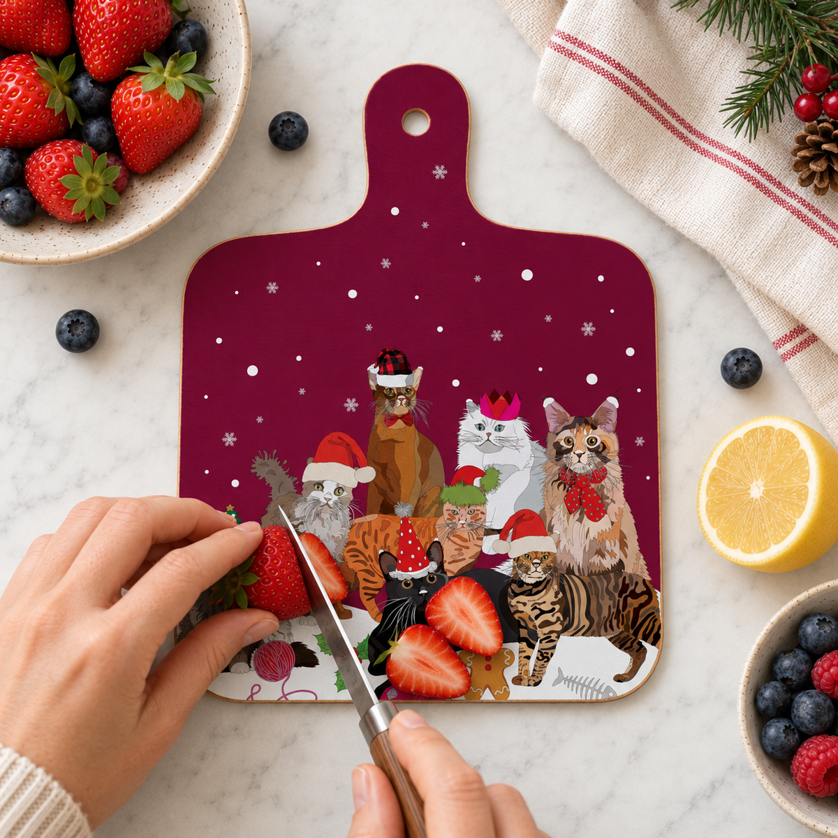 Christmas Cats melamine mini chopping board with festive cat illustrations, shown in a kitchen flat lay while slicing strawberries with berries, lemon and Christmas greenery.

Festive front and back mockup: