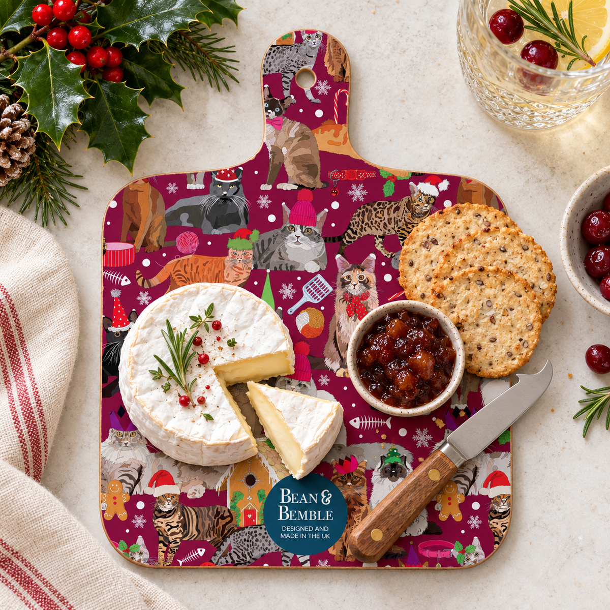Cheese board mockup:
Christmas Cats mini melamine cheese board styled with Brie, crackers, chutney and a cheese knife, surrounded by festive greenery, berries and Christmas details.