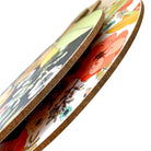 Side view of round melamine chopping board with patterned surface and brown edge