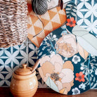 Large round floral chopping board with dark blue base and cream flower illustrations