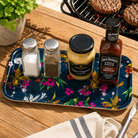 Cherry Blossom navy small melamine tray holding salt, pepper, mustard and barbecue sauce on an outdoor wooden table.