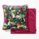 A square throw pillow with a dark green background and a colorful equestrian floral print, shown next to its matching deep pink velvet reverse side.