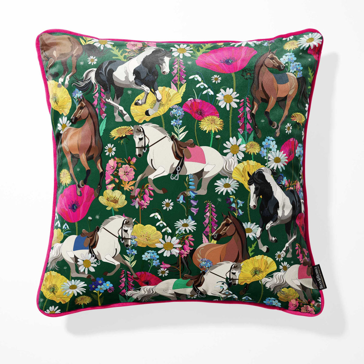 A square throw pillow featuring a vibrant equestrian pattern with horses and flowers on a dark green background, finished with a bright pink piped edge.