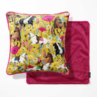 A square decorative pillow with a vibrant horse-and-floral print on a mustard yellow background with a hot pink back.